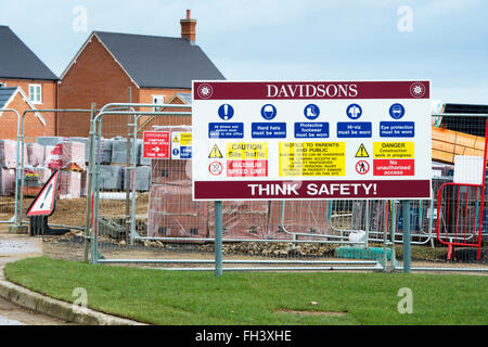 La salute e i segnali per la sicurezza posti sul perimetro della scatola Davidsons sito in costruzione a Brackley, Northamptonshire, Inghilterra Foto Stock