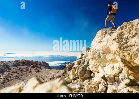 L'uomo turista escursionista o trail runner guardando il bellissimo paesaggio di ispirazione in alta montagna. Runner maschio con zaino, gioia Foto Stock