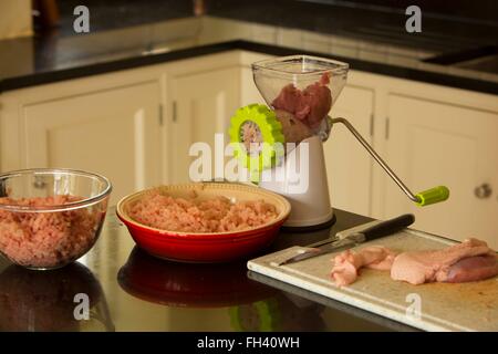 Cosce di pollo giacente su di un tagliere in procinto di essere macinate in una casa famiglia cucina Foto Stock