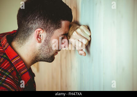 Ha sottolineato l'uomo appoggiata contro la parete Foto Stock