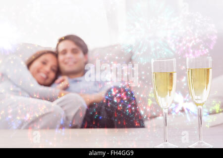 Immagine composita del giovane in appoggio su di un lettino con flauti di champagne Foto Stock