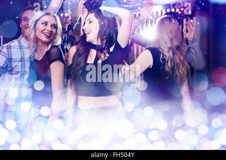 Immagine composita di elegante amici ballare e sorridente Foto Stock