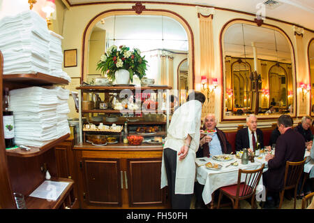 PARIGI, Francia, - adulti che condividono i pasti, all'interno del ristorante francese. Classico bistrot parigino, cameriere 'Chez Georges' che serve tavoli, cena classica al ristorante Foto Stock