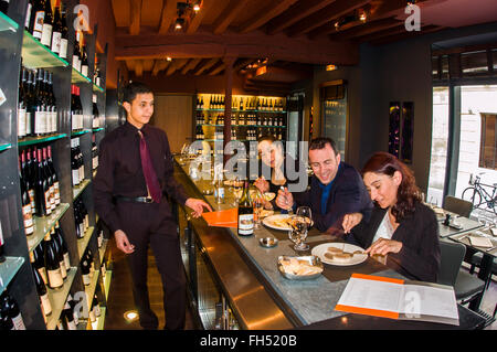 PARIGI, Francia, - adulti che condividono i pasti al banco del ristorante Bistro francese. Pranzo d'affari all'Atelier Maitre Albert (Guy Savoy, Jean-Michel Wilmotte, Interior Design). Banco pranzo con vista grandangolare Foto Stock