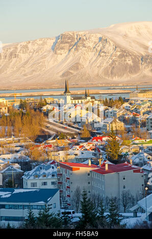 Islanda Reykjavic guardando giù città soleggiata panoramica dello skyline di gennaio, sfondo di montagna visto da Perlan (Pearl) Hotel. Foto Stock