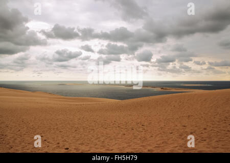 Dune di Pilat, vista sull'oceano e cielo nuvoloso. Dune du Pilat, le più alte dune di sabbia in Europa, che si trova nella baia di Arcachon un Foto Stock