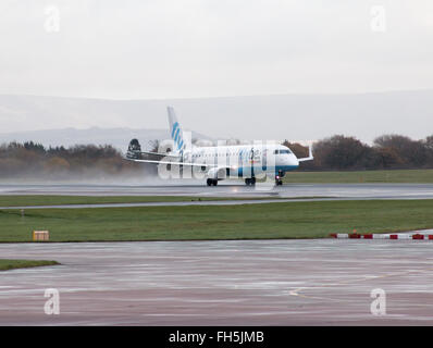 Flybe Embraer E175 corpo stretto piano passeggero (G-FBJB) decollo dall'Aeroporto Internazionale di Manchester sulla pista. Foto Stock