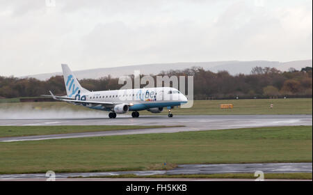 Flybe Embraer E175 corpo stretto piano passeggero (G-FBJB) decollo dall'Aeroporto Internazionale di Manchester sulla pista. Foto Stock