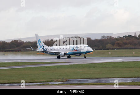 Flybe Embraer E175 corpo stretto piano passeggero (G-FBJB) decollo dall'Aeroporto Internazionale di Manchester sulla pista. Foto Stock