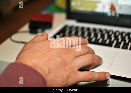 mano e computer portatile Foto Stock