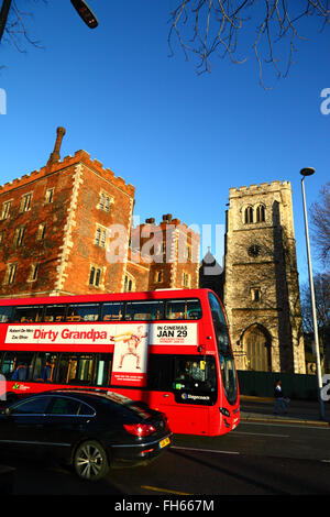 Bus rosso a due piani pubblicità sporco nonno passando il Morton's Tower, parte di Lambeth Palace a Londra, Inghilterra Foto Stock