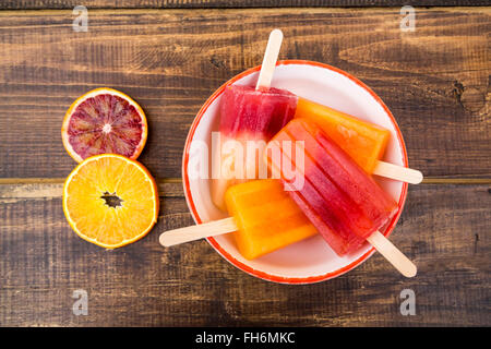 Ciotola di diverso colore arancione in casa ghiaccioli Foto Stock