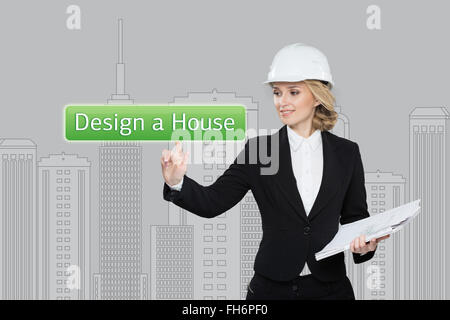 Business Woman desing premendo un pulsante hause su schermi virtuali. Blocchi residenziali. Business, tecnologia internet e il concetto di rete Foto Stock