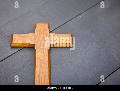 Pasqua in legno croce sul nero lo sfondo di legno Foto Stock