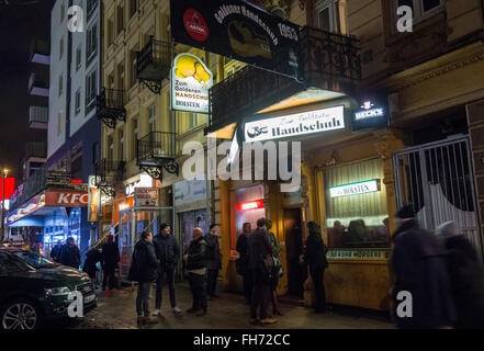 Amburgo, Germania. Il 23 febbraio, 2016. Gli ospiti si alzano in piedi davanti al "Zum goldenen Hanschuh' pub prima della presentazione di un libro da autore Heinz Strunk in Amburgo, Germania, 23 febbraio 2016. Vi Strunk presenta il suo nuovo romanzo 'Der goldene Handschuh' (Il Golden guanto) circa assassino Fritz Honka. Il libro arriva a memorizza il 26 febbraio 2016. Foto: CHRISTIAN CHARISIUS/dpa/Alamy Live News Foto Stock