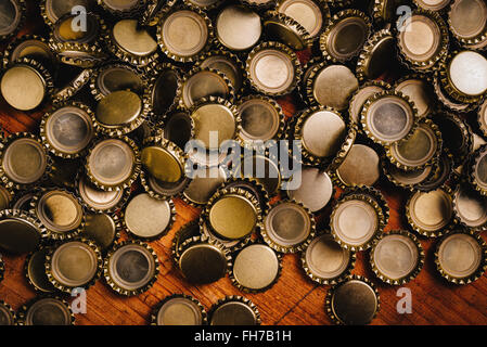 Gran mucchio di birra i tappi di bottiglia in rovere rustico scrivania in legno Foto Stock