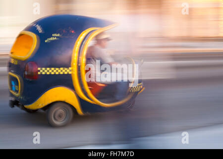 Cocotaxi, coco taxi, accelerando lungo la strada di El Malecon, Havana, Cuba, West Indies, dei Caraibi e America centrale Foto Stock