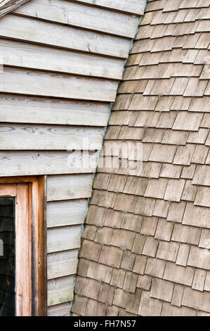 Herefordshire, Regno Unito. Un dettaglio di un auto costruita casa, rivestita di legno con un tetto curvo con coperta in legno Scandole di cedro Foto Stock
