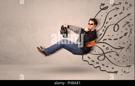 Funny uomo alla guida di un veicolo in volo con mano le linee tracciate dopo di lui Foto Stock