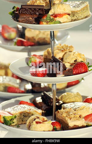 Pasticcini su una torta davanti a un buffet. Messa a fuoco selettiva con una buona separazione di profondità. Foto Stock