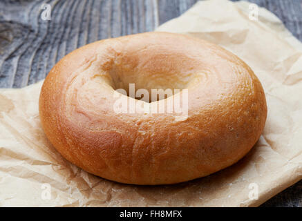 Bagel freschi nel sacchetto di carta sul tavolo in legno Foto Stock