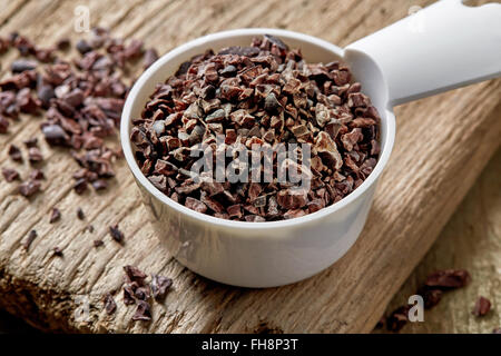 Misurino di cacao naselli sul tavolo di legno Foto Stock