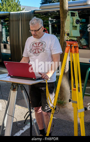 Topografo che prende misure con Leica TCR 307 teodolite e computer portatile Street desk France Europe Foto Stock