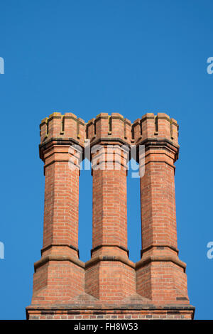 Gruppo di tre tudor ciminiere in laterizio a Hampton Court Palace a Londra, Inghilterra Foto Stock