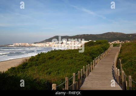 Passerella in legno attraverso la vegetazione sulle dune di sabbia, Vila Praia de ancora in background, Provincia del Minho, Portogallo settentrionale Foto Stock