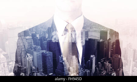 Business man in piedi sul tetto con città sullo sfondo Foto Stock