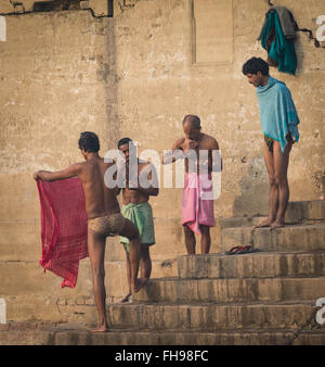 Gli uomini stanno facendo il loro rituale mattutino dalle rive del Gange a Varanasi, India Foto Stock