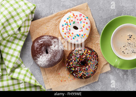 Le ciambelle e caffè sul tavolo di pietra. Vista superiore Foto Stock