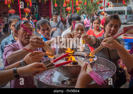 I buddisti di incenso di illuminazione per le offerte in Chinatown, Bangkok, Thailandia Foto Stock