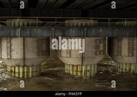 Ponte delle colonne di supporto che sorge fuori del fiume Foto Stock