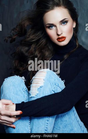 Ragazza con lunghi capelli ricci in un black turtleneck. Foto Stock