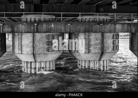 Ponte delle colonne di supporto che sorge fuori del fiume Foto Stock