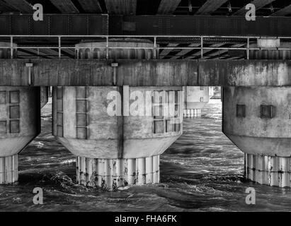 Ponte delle colonne di supporto che sorge fuori del fiume Foto Stock