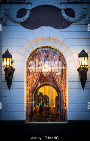 Finestra di cafe a Budapest, in Ungheria, in Europa. Le decorazioni di Natale e le luci. Due grandi lampade stradali sui lati della finestra. Accogliente e Foto Stock