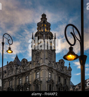 Via la luce e il vecchio edificio al tramonto a Budapest, in Ungheria, in Europa. La luce gialla delle lampade contro Blu Cielo di tramonto con le nuvole. Foto Stock