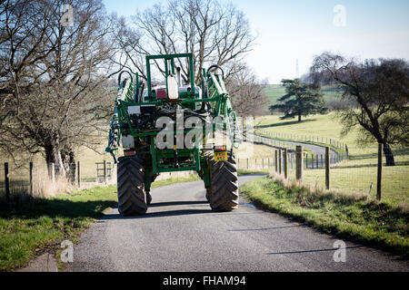 Un grande veicolo agricolo il riempimento di una stretta viuzza in un paese di campagna,eventualmente provocando un inceppamento di traffico o tailback Foto Stock