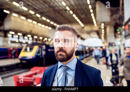 Close up, hipster imprenditore in attesa presso la stazione ferroviaria Foto Stock