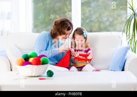 Madre e figlia maglia Sciarpa di lana. Mom insegnamento bambino a lavorare a maglia. Artigianato e hobby per i genitori e per i bambini. Foto Stock