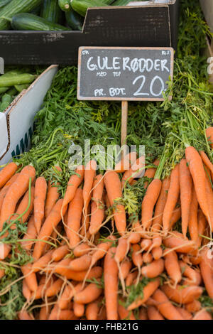 Orange carotine accatastati sul tavolo nel mercato locale Foto Stock