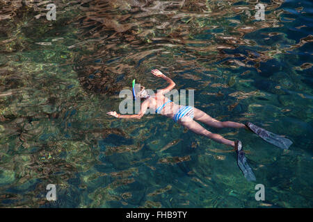 Giovane donna lo snorkeling nella laguna tropicale Foto Stock