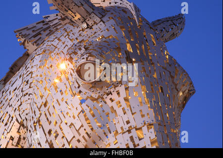 Dettaglio dell'occhio di uno dei Kelpies, illuminate al tramonto, il più grande del mondo di sculture di cavalli, a Falkirk, Scotland, Regno Unito Foto Stock