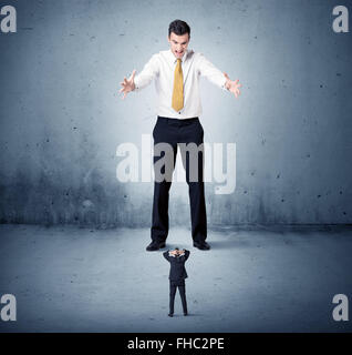 Arrabbiato enorme business man lokking al piccolo ragazzo Foto Stock