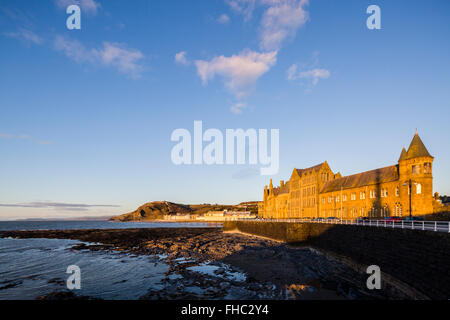 Il vecchio collegio a Aberystwyth illuminata da un caldo tramonto Foto Stock