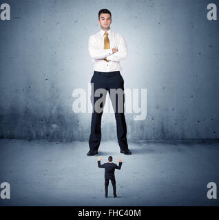 Arrabbiato enorme business man lokking al piccolo ragazzo Foto Stock