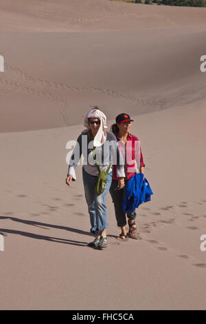 Visitatori escursione in grandi dune di sabbia del Parco Nazionale che contiene le più grandi dune di sabbia in America del Nord - COLORADO MR Foto Stock