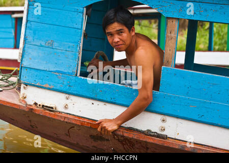 Il laotiano uomo aziona una barca sul fiume Mekong- Luang Prabang, Laos Foto Stock